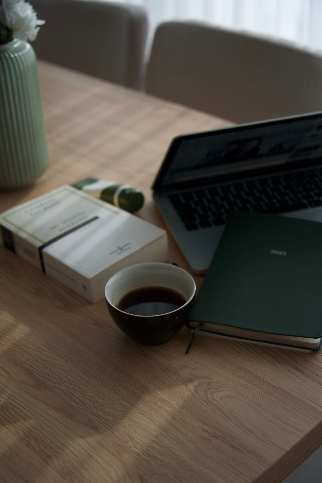 A green notebook on a desk
